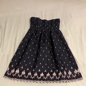 Strapless navy dress with stitched white detail.